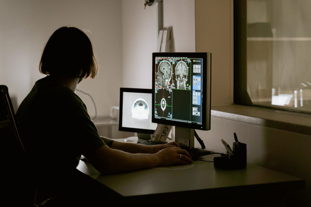 Researcher reviewing brain MRI images on computer monitors