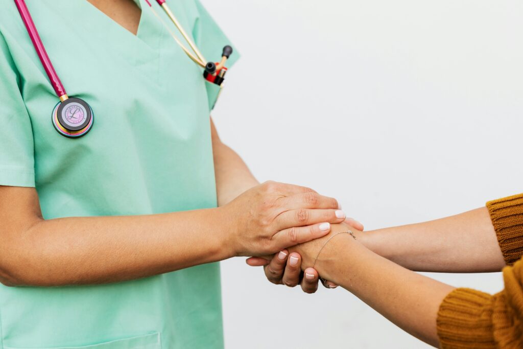 An image showing a medical professional holding the hands of a patient